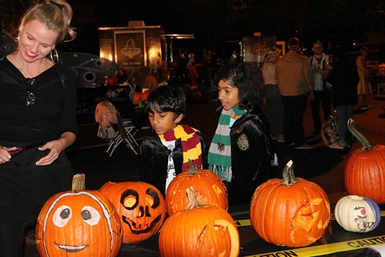 kids looking at carved pumpkins
