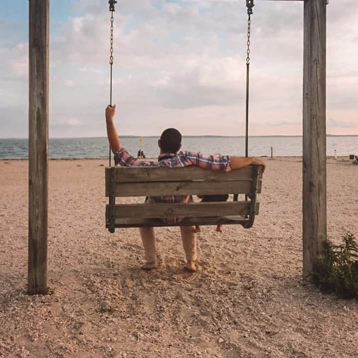 Picture of Christopher Lara sitting with his son on a swinging bench at a lake