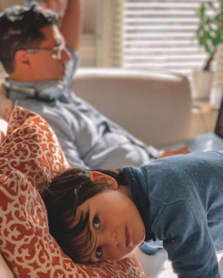 Picture of Christopher Lara sitting on a couch with his son as he works on digital marketing services